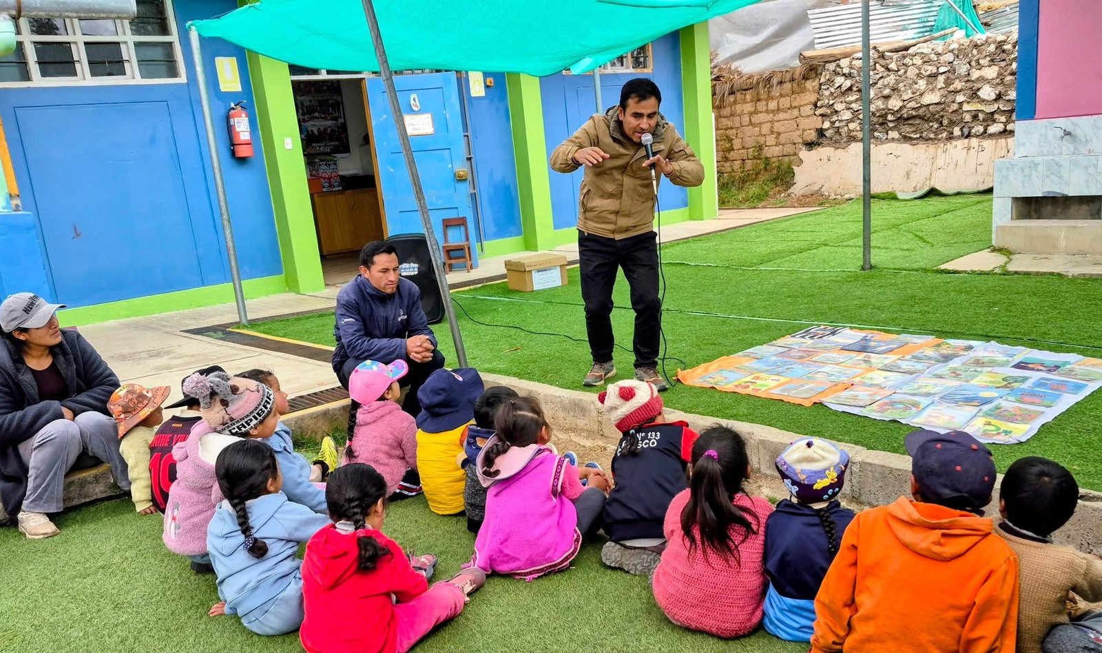 El profesor Danny Bernales relata una historia a los niños reunidos en el patio.
