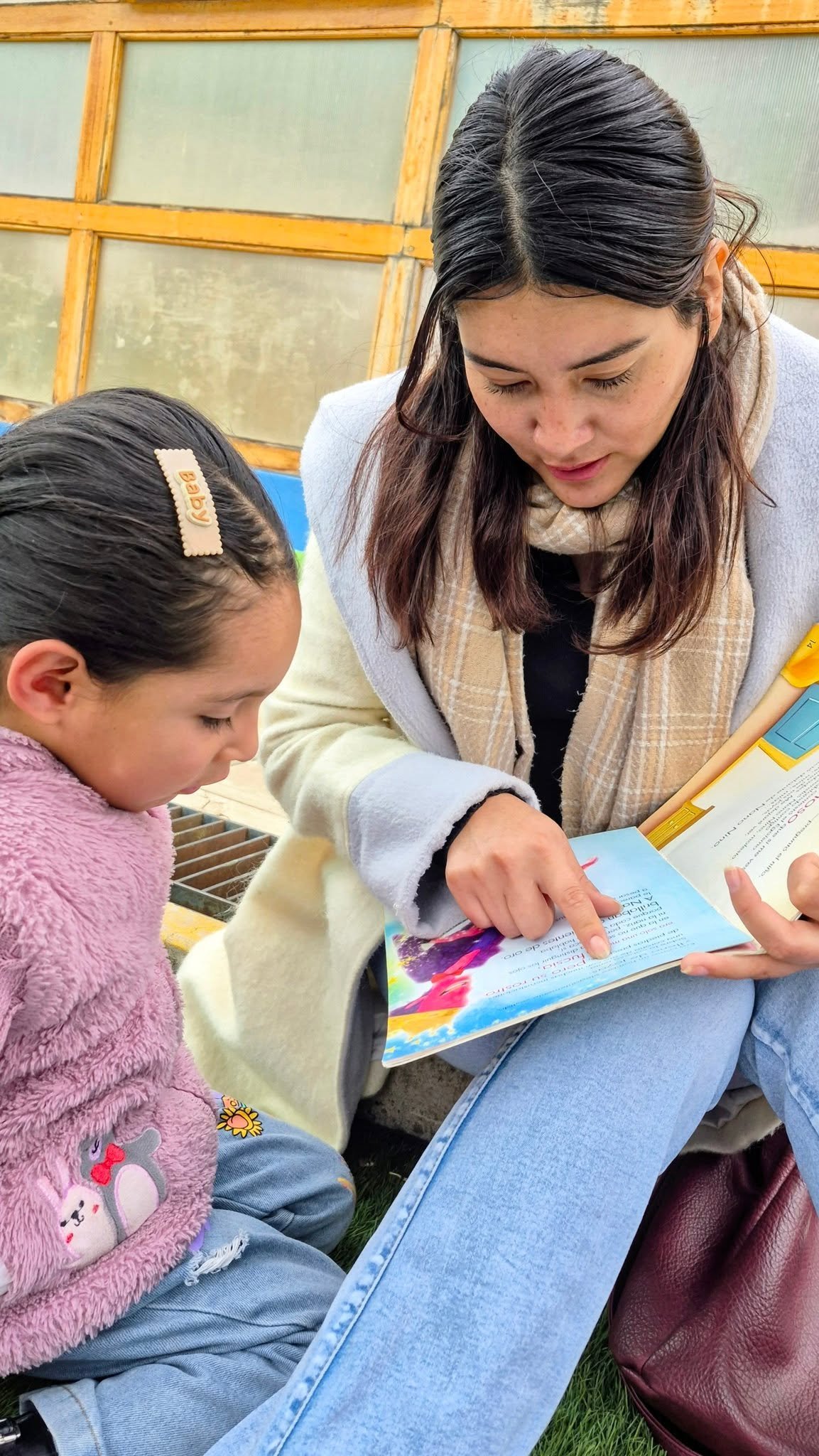 Madre e hija comparten un libro durante la jornada de lectura.