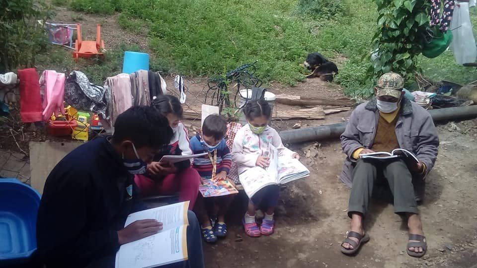 Niños y adultos compartiendo un momento de lectura al aire libre